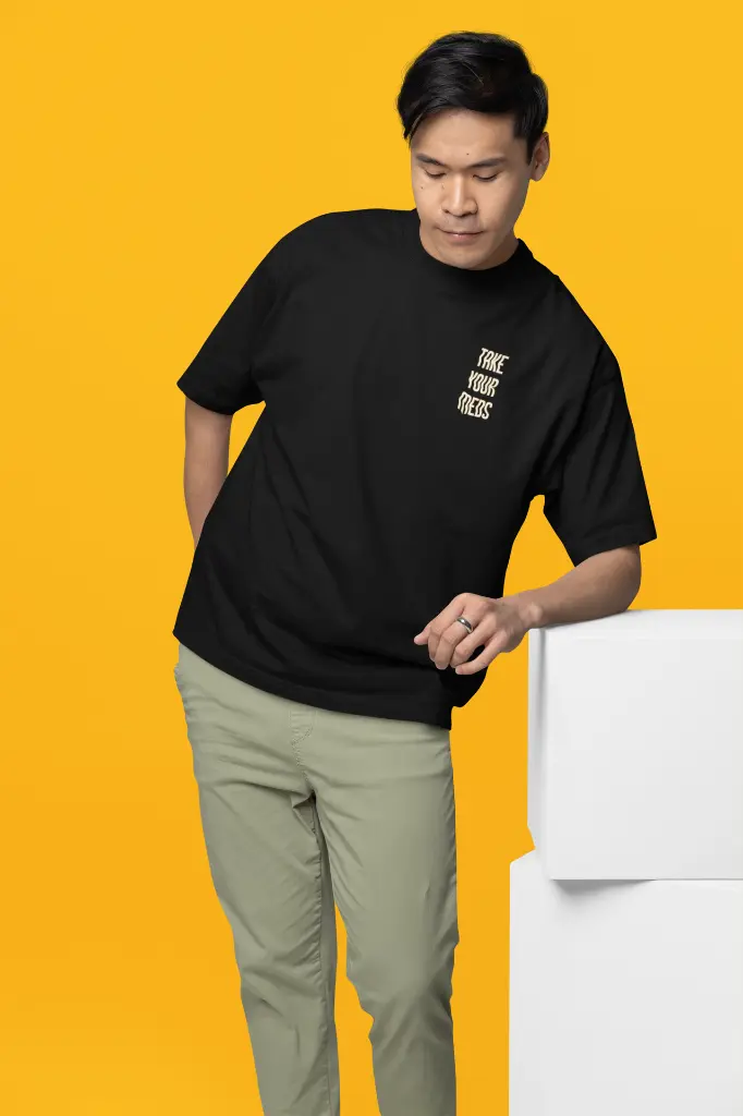 oversized-t-shirt-mockup-featuring-a-man-leaning-on-a-colorful-cube-m38921.webp